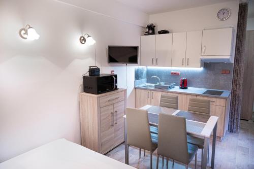 a small kitchen with a table and chairs in a room at Rezidence Rokytnice in Rokytnice nad Jizerou