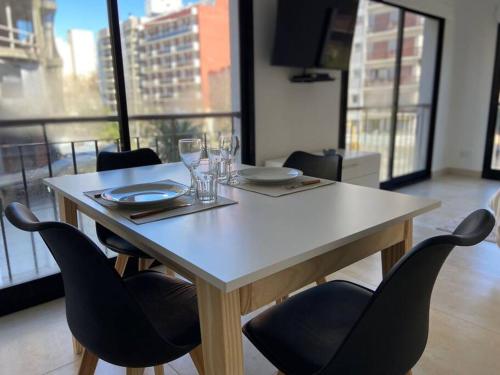 a dining room table with chairs and a large window at B Excepcional monoambiente en Mar del Plata a metros del mar in Mar del Plata