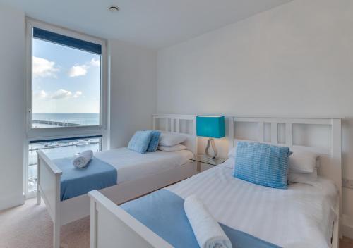 a bedroom with two beds and a large window at Orion in Brighton & Hove