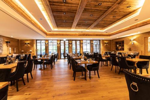 a restaurant with wooden ceilings and tables and chairs at Waldhotel Luise in Freudenstadt