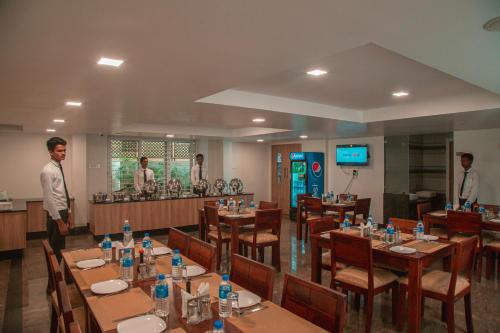 a restaurant with tables and people standing in the kitchen at Park Avenue Suites in Coimbatore