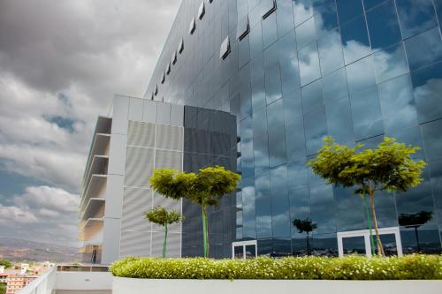 a glass building with trees in front of it at Kariris Blue Tower in Crato