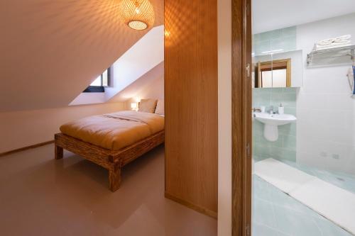 een slaapkamer met een bed en een badkamer met een wastafel bij Apartamento Cabra Playa de Langosteira en Finisterre con vistas al mar in San Martín de Arriba