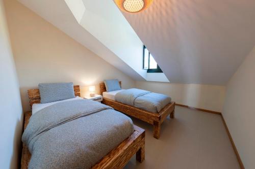 een slaapkamer op zolder met 2 bedden en een raam bij Apartamento Cabra Playa de Langosteira en Finisterre con vistas al mar in San Martín de Arriba