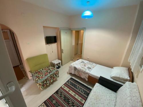 um quarto com duas camas e uma cadeira e uma televisão em ALTAY MOTEL em Yalova