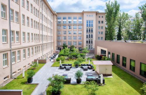 an apartment courtyard with furniture and buildings at Leonardo Royal Hotel Berlin Alexanderplatz in Berlin