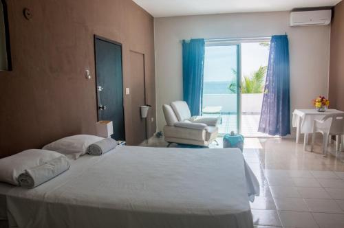 a bedroom with a bed and a chair and a window at CANCUN PRIVATE APARTMENT in Cancún