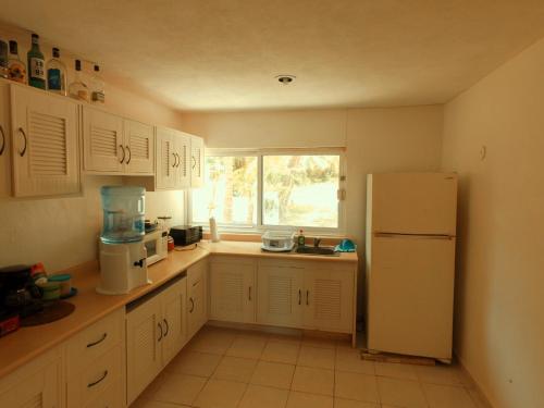 a kitchen with a white refrigerator and a window at CANCUN PRIVATE APARTMENT in Cancún