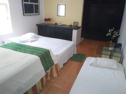 a bedroom with two beds and a table with flowers at CANCUN PRIVATE APARTMENT in Cancún