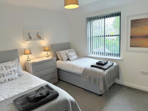 una camera da letto con due letti e una finestra di Kilmuir Cottage a Tomintoul