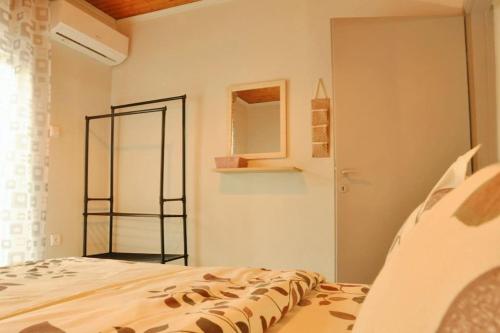 Schlafzimmer mit einem Bett und einem Wandspiegel in der Unterkunft TasoulasHome 1-μονοκατοικια με αυλη in Komotiní