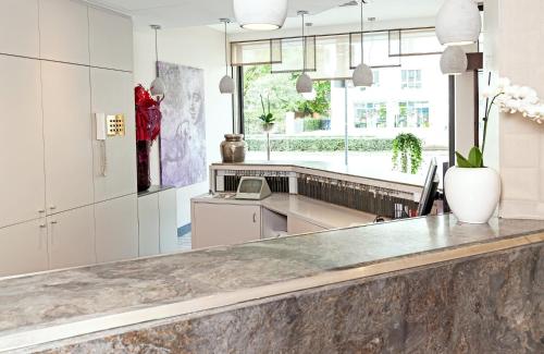 a kitchen with a counter and a large window at Leonardo Hotel Munich City North in Munich