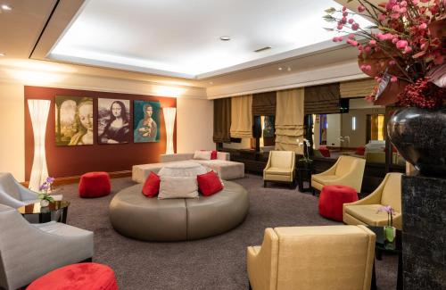a living room with couches and chairs and a salon at Leonardo Hotel Frankfurt City South in Frankfurt