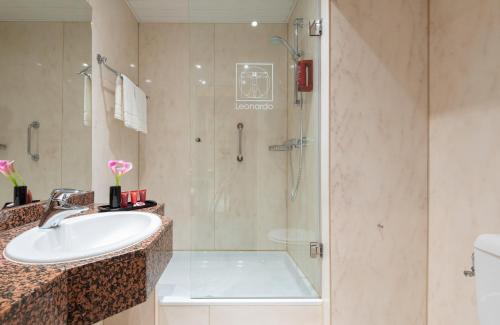 a bathroom with a sink and a shower at Leonardo Hotel Frankfurt City South in Frankfurt/Main