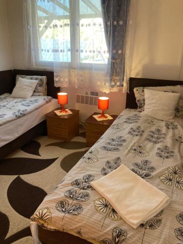 2 camas en una habitación con 2 lámparas en las mesas en Vacsacsi vendégház en Berekfürdő