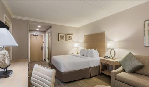 Habitación de hotel con cama blanca y sofá en Holiday Inn Express Fairhope - Point Clear, an IHG Hotel, en Fairhope
