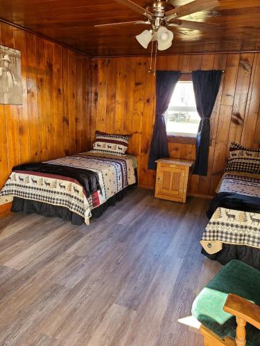 a bedroom with two beds and a ceiling fan at Eagle Rock Resort in Naches