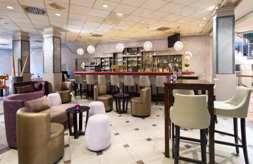 a bar in a restaurant with chairs and tables at Leonardo Hotel Köln in Cologne