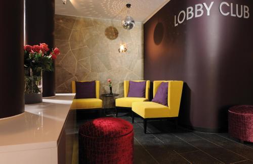 a waiting room with yellow chairs and purple seats at Leonardo Boutique Hotel Munich in Munich