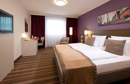 Postel nebo postele na pokoji v ubytování Leonardo Hotel Köln