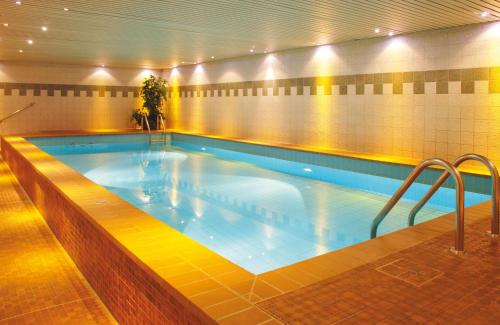 a large swimming pool in a building at Leonardo Hotel Köln in Cologne