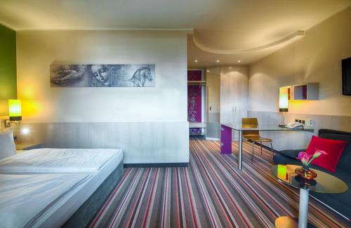 ein Hotelzimmer mit einem Bett und einem Tisch in der Unterkunft Leonardo Hotel & Residenz Muenchen in München