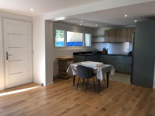 une cuisine avec une table et des chaises dans une pièce dans l'établissement Le Colombier, à Annecy