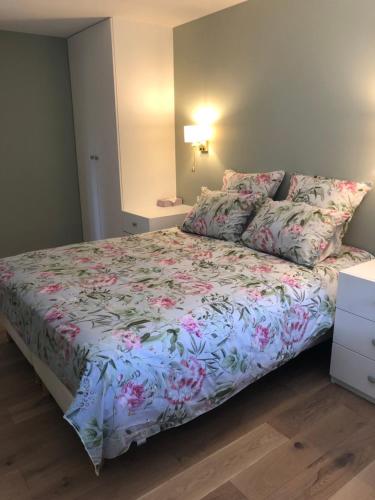 a bedroom with a bed with a floral bedspread at Le Colombier in Annecy