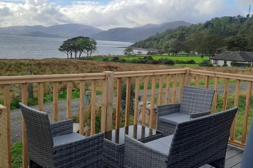 a patio with two chairs and a table on a balcony at Dalrigh Pod in Onich