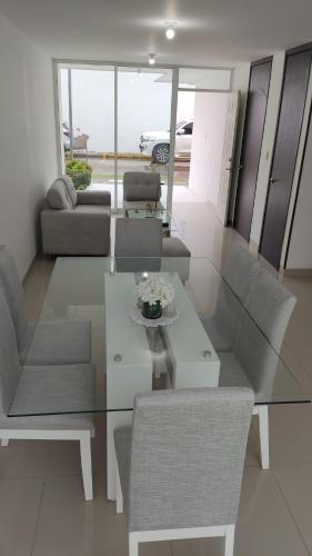 una mesa de cristal y sillas en la sala de estar. en Casa Condominio Diomedes Daza Valledupar en Valledupar