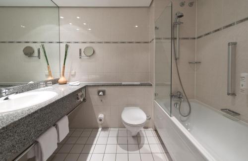 e bagno con servizi igienici, lavandino e doccia. di Leonardo Hotel Heidelberg a Heidelberg