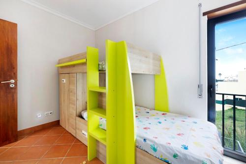 a bedroom with a bunk bed and a yellow ladder at Casa Vale do Paraíso in Sesimbra
