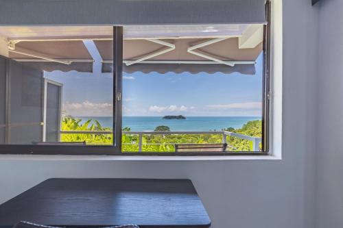 a room with a window with a view of the ocean at Hotel Villas de la Selva in Manuel Antonio