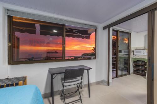 a dining room with a table and a view of the ocean at Hotel Villas de la Selva in Manuel Antonio