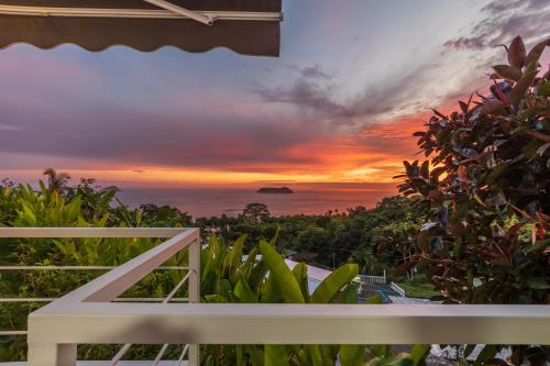 uma vista para o pôr-do-sol a partir da varanda de uma casa em Villas de la Selva em Manuel Antonio