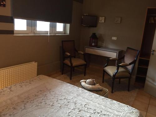 a bedroom with a bed and two chairs and a desk at MARGOT'L in Rochefort