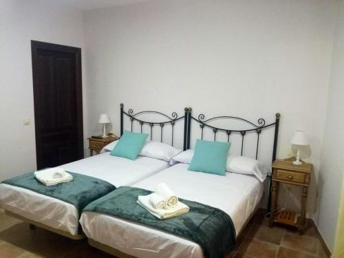 um quarto com 2 camas com almofadas azuis e brancas em 3 bedrooms villa with private pool and furnished terrace at Las Casas em Las Casas
