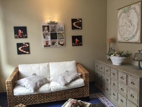 a living room with a white couch and a dresser at MARGOT'L in Rochefort