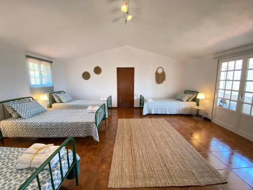 a living room with three beds and a rug at Villa Samaritana - Casa da Vinha in Vila Marim