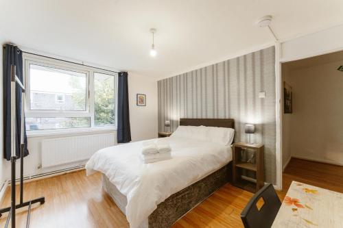 a bedroom with a large white bed and a window at Langdon Park DLR beds to stay in London