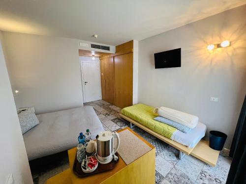 a small room with two beds and a table at hotel garni Santa Caterina in Orta San Giulio