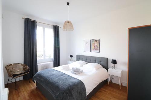 a bedroom with a bed and a chair and a window at Superbe Appartement de 45m² à Antony in Antony