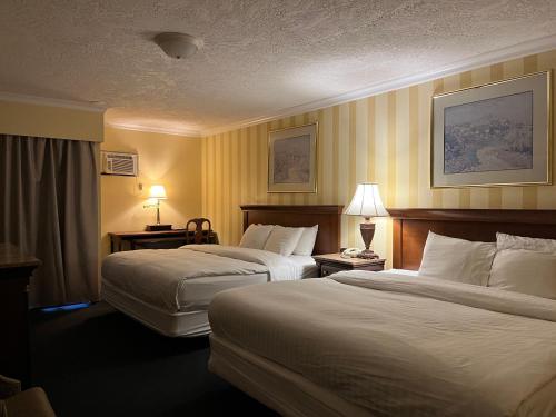 a hotel room with two beds and two lamps at Island Travel Inn in Victoria