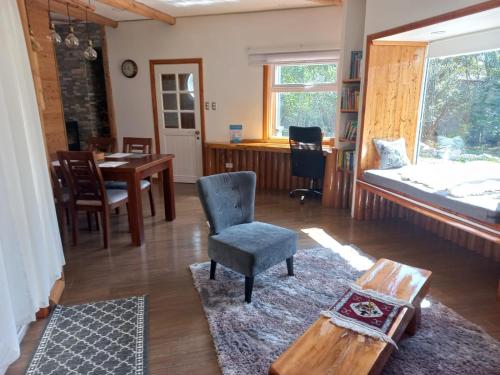 uma sala de estar com uma mesa e uma cadeira em Cabañas Chaya Mapu em Puerto Aisén