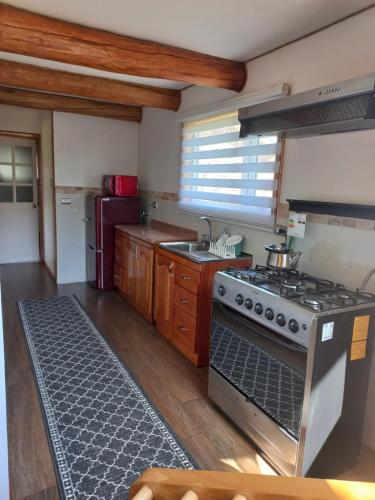 a kitchen with a stove and a sink at Cabañas Chaya Mapu in Puerto Aisén