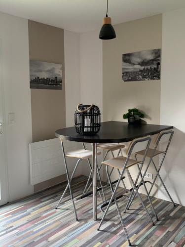 einen schwarzen Tisch und Stühle in einem Zimmer in der Unterkunft IBI ENJOY le petit in Ligné