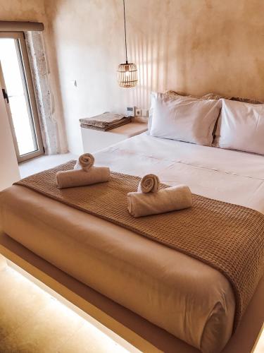 a bedroom with a bed with two towels on it at Mani Luxury Suites and Studios in Gytheio with Private Pools in Gythio