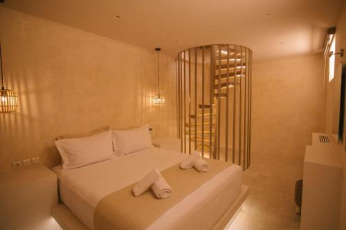 a bedroom with a bed with two towels on it at Mani Luxury Suites and Studios in Gytheio with Private Pools in Gythio
