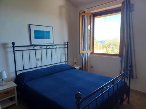 una camera con un letto blu e una finestra di CASA MARGOT(RELAX CON VISTA) a Arenella