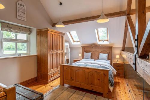 a bedroom with a wooden bed and wooden floors at Waterside Cottage in Harrogate